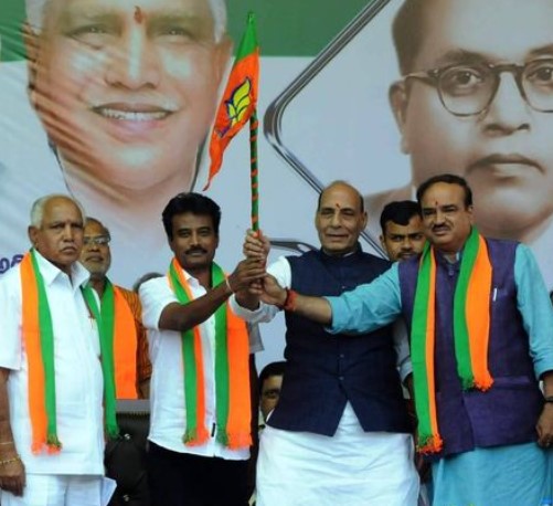 K. Shivaram while attending a political rally of the BJP along with Rajnath Singh.
