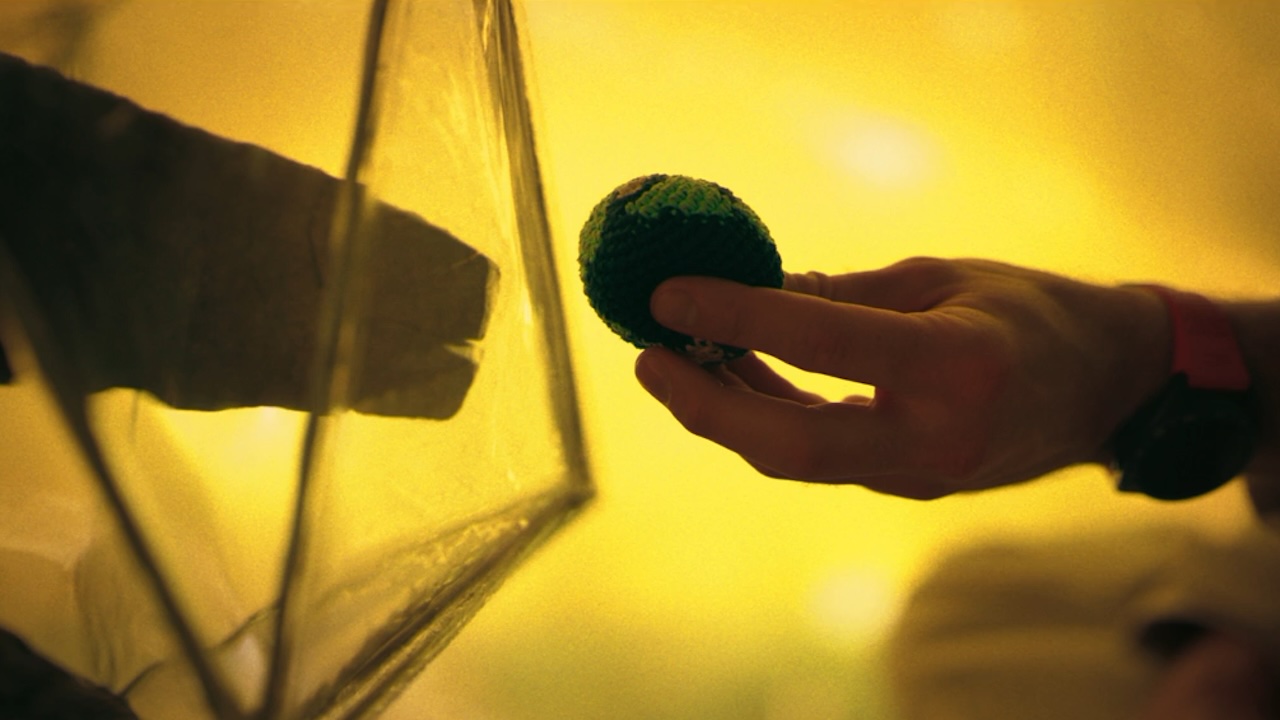 پروجیکٹ ہیل میری میں ایک اجنبی ہاتھ میں زمین کا کھلونا پکڑے ہوئے ایک ہاتھ