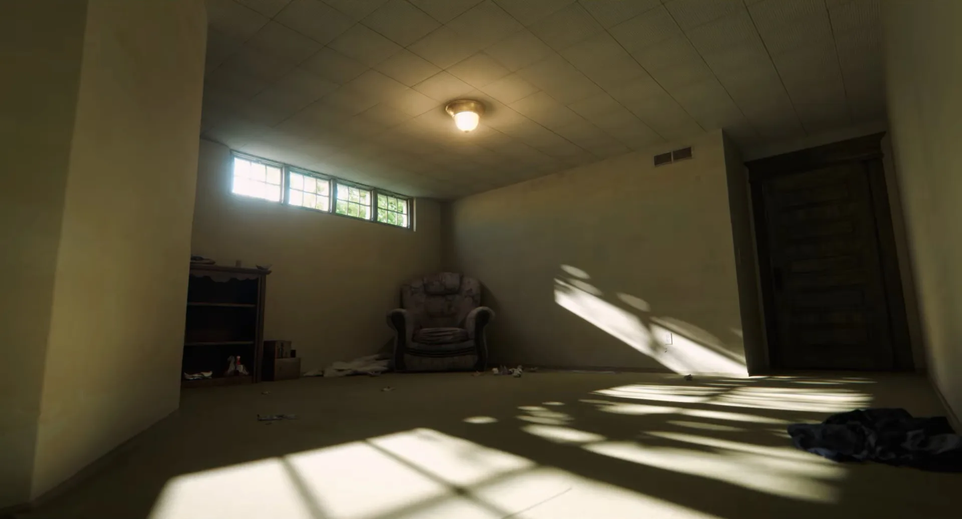 An empty room at A24's The Backrooms is lined with sofa chairs and books.