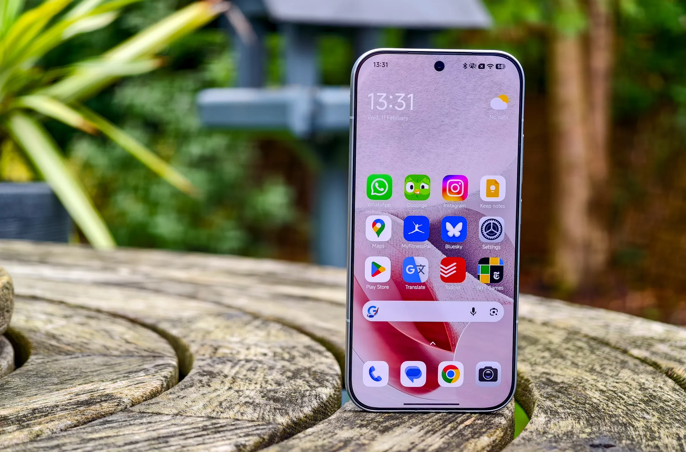 باہر لکڑی کی میز پر Xiaomi 17 ہوم اسکرین کی تصویر