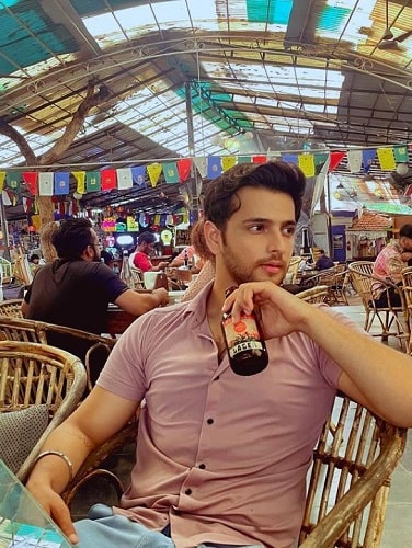 Shivam Khajuria holding a bottle of beer