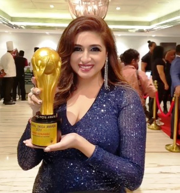 Vahbiz poses for a photo with the Universal India Award.
