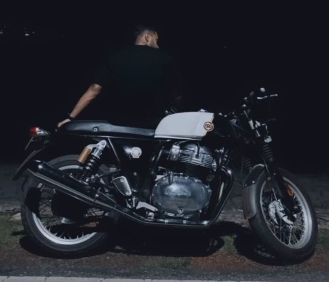 Sushant Mishra sitting on his Royal Enfield Continental GT 650 bike.