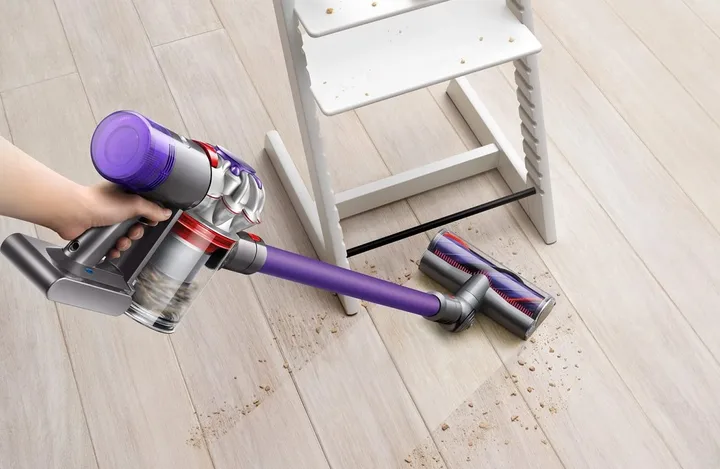 A person using the Dyson V8 Origin Plus cordless vacuum cleaner.
