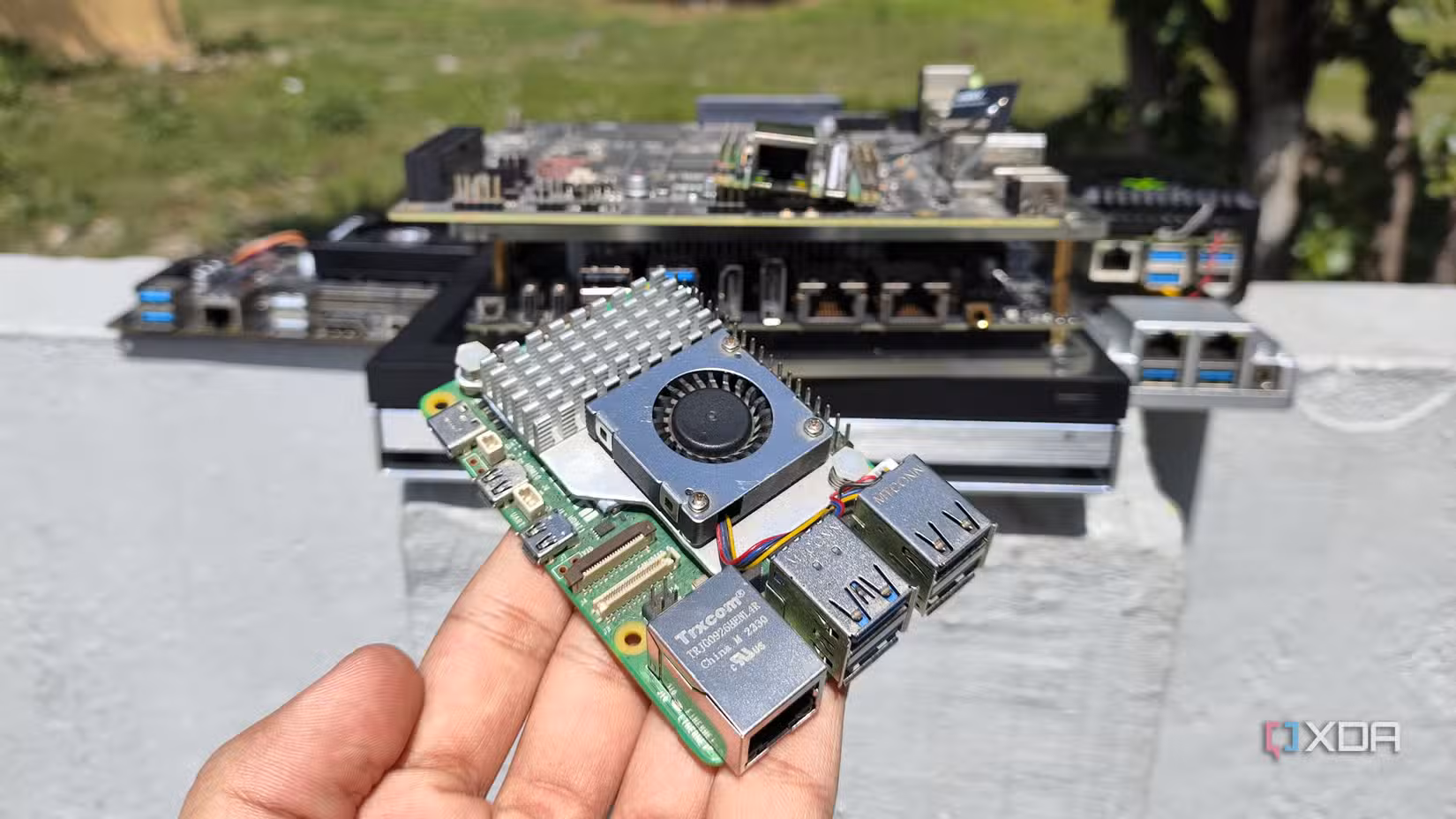 ایک شخص دوسرے SBCs، mini PCs، اور NAS کے سامنے Raspberry Pi پکڑے ہوئے ہے۔