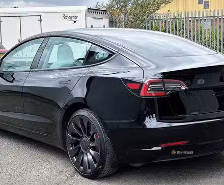 ایک سیاہ 2021 Tesla ماڈل 3 کارکردگی کا جامد پیچھے 3/4 شاٹ۔