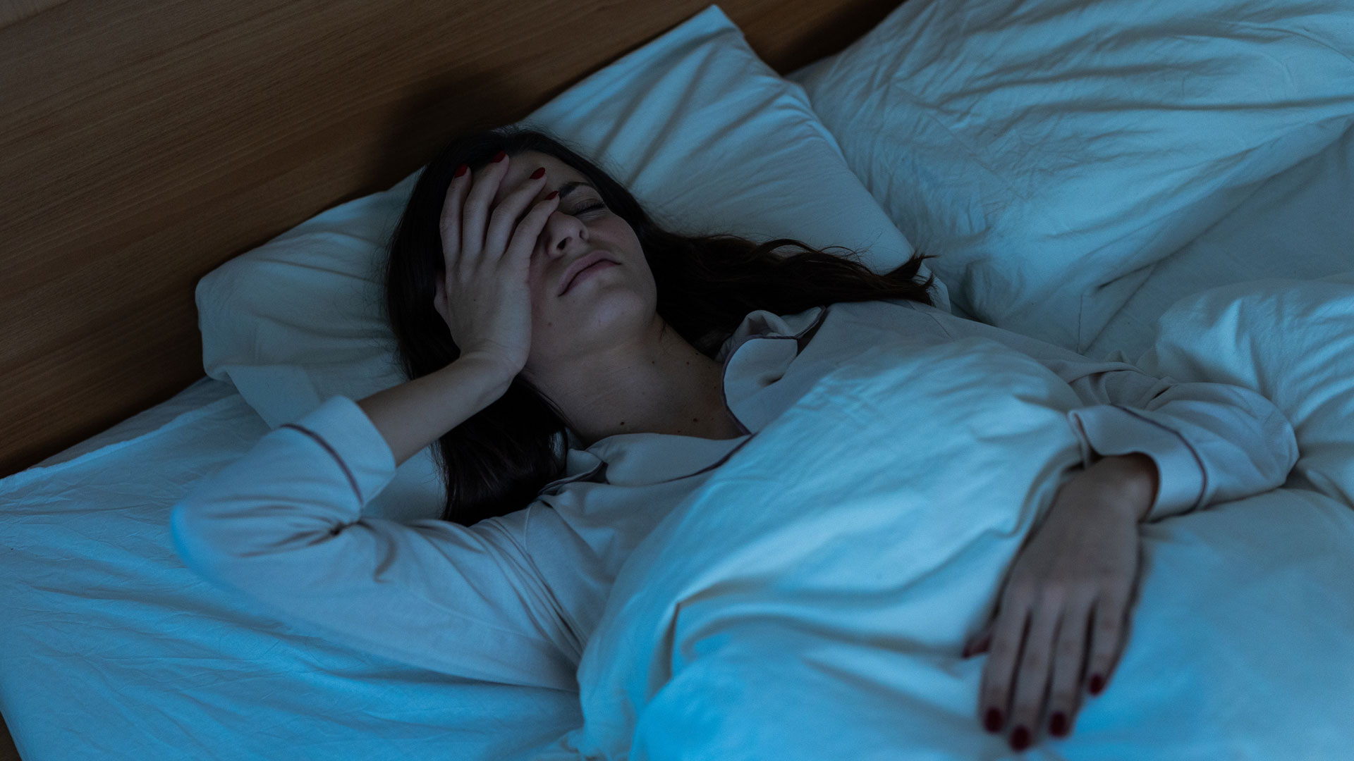 ایک عورت بستر پر لیٹی ہے جو سو نہیں پا رہی ہے۔