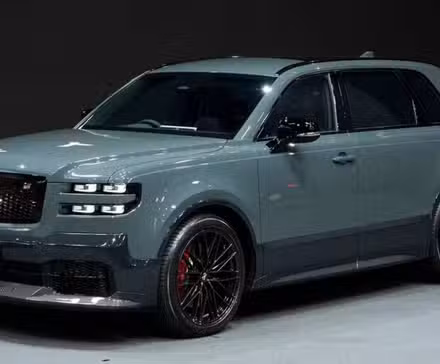 سیاہ پس منظر کے خلاف اسٹیج پر گرے 2024 ٹویوٹا سنچری SUV کا سامنے کا تین چوتھائی منظر۔