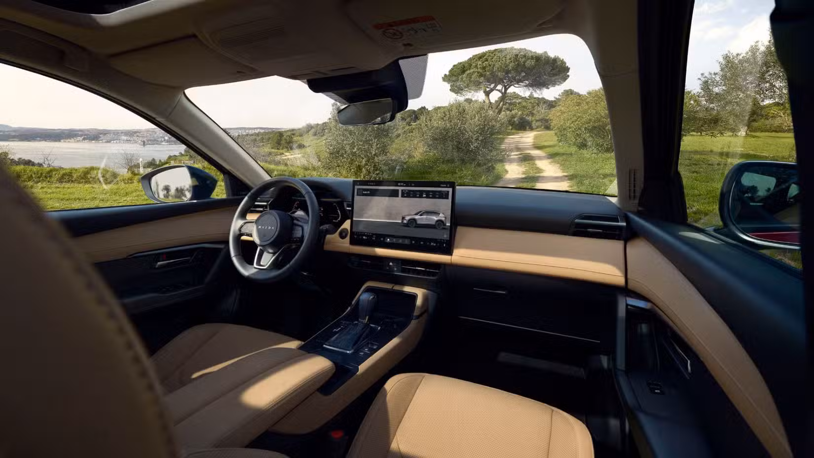 2026 Mazda CX-5 کے کیبن کے اندرونی حصے کا ایک شاٹ، سامنے کی سیٹیں اور ڈیش بورڈ دکھا رہا ہے۔