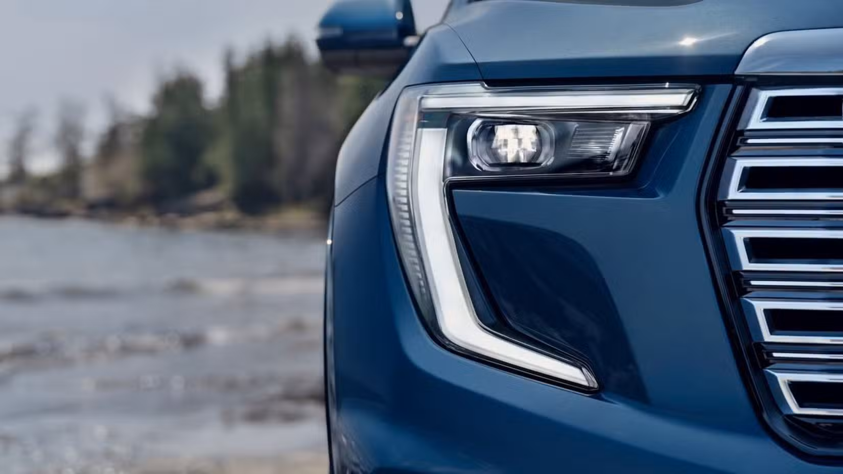 نیلی 2024 GMC Acadia کی ہیڈلائٹس کی کلوز اپ تصویر۔