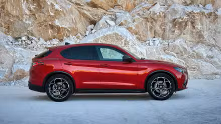 کم جگہ والی BMW SUV کے لیے $80,000 ادا نہ کریں۔ X5 کم میں سب کچھ بہتر کرتا ہے۔ 5 ایک سرخ 2023 الفا رومیو اسٹیلیو کی جامد سائیڈ پروفائل تصویر۔