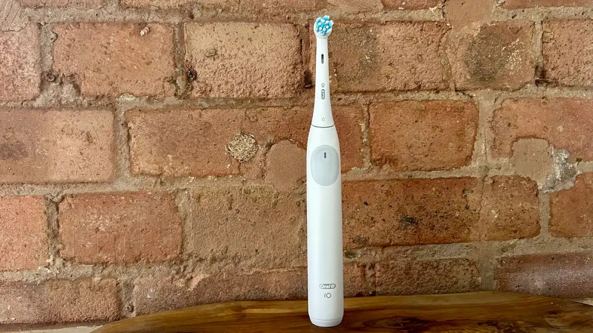 بہترین Oral-B الیکٹرک ٹوتھ برش 2026 29 Oral-B iO2 اینٹوں کی دیوار سے جھکا ہوا ہے۔